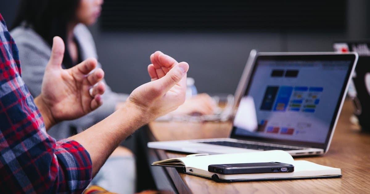 Team comparing project management tools on a laptop during a workspace discussion