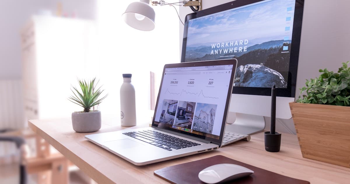 Clean modern workspace with a laptop showing analytics dashboard on a wooden desk