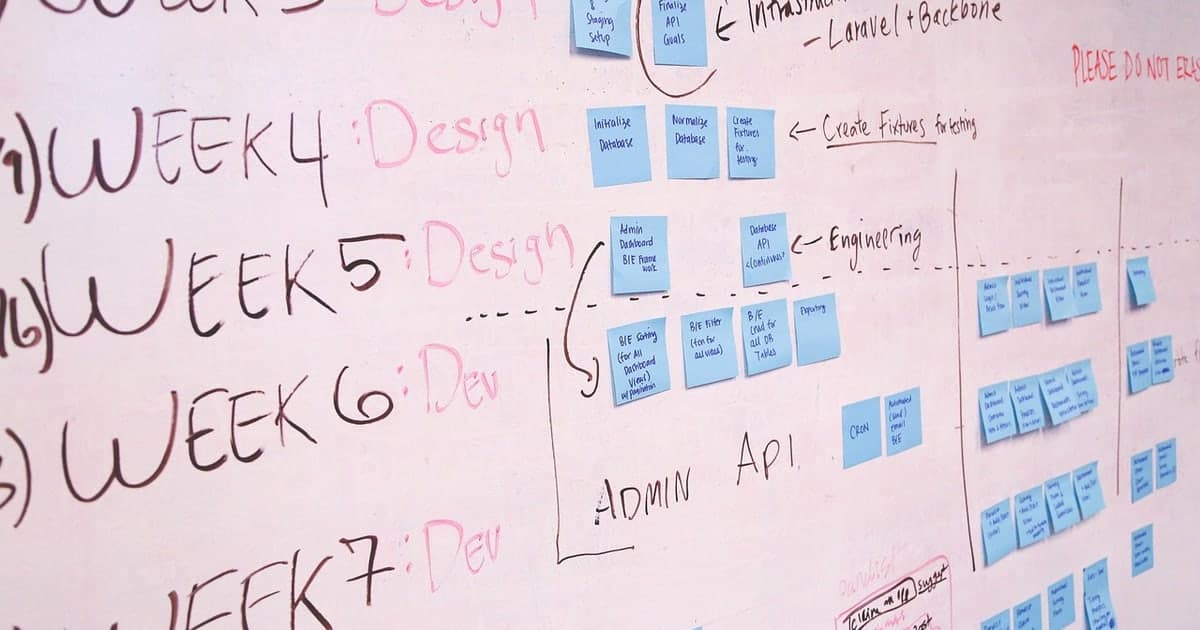 Person writing project plans at a desk representing modern cloud alternatives to Microsoft Project in 2026