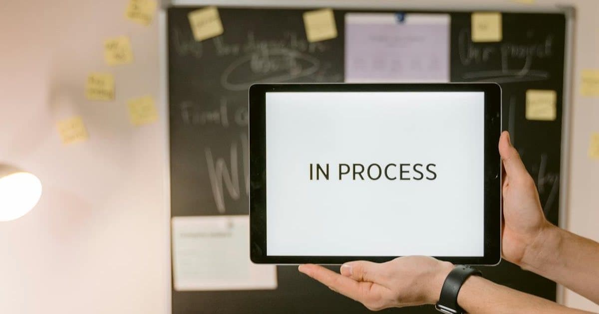 Tablet wyświetlający status workflow In Process - porównanie zarządzania zadaniami między ClickUp i Asana w 2026