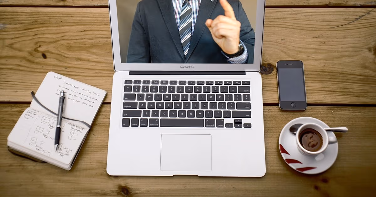 Laptop and notebook on a desk representing AI meeting assistants that transcribe and summarise calls
