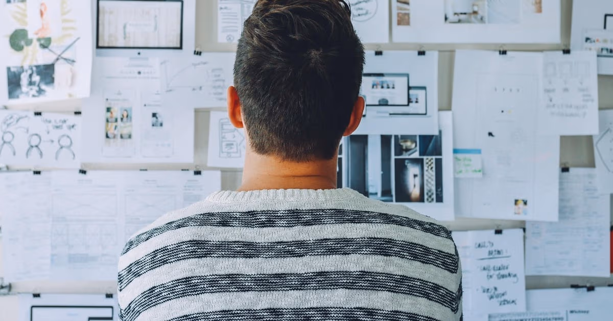 Zwei Führungskräfte arbeiten an einem Strategieplan mit Notizbüchern, Diagrammen und Laptops an einem Arbeitstisch