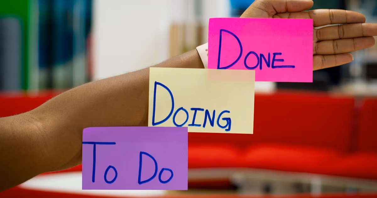 Hand holding To Do, Doing, Done sticky notes on an arm - representing the simple Kanban philosophy at the heart of the ClickUp vs Trello decision