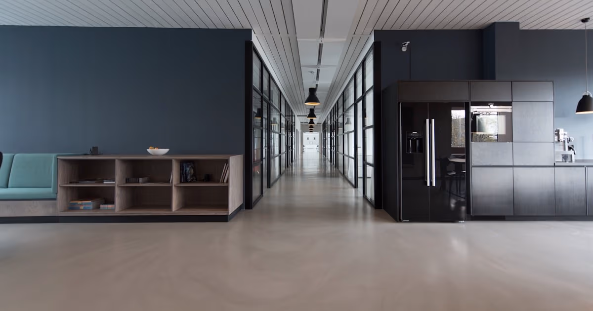 Modern enterprise office corridor with glass-walled meeting rooms - representing the enterprise governance vs flexibility decision between ClickUp and Wrike