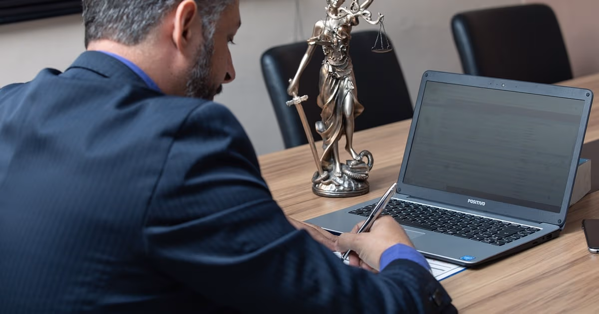 Solo lawyer reviewing client intake enquiries and consultation bookings on a laptop in a small law office