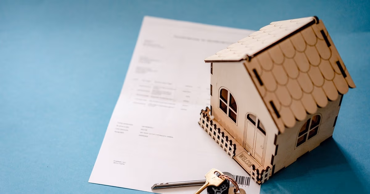 Real estate investor reviewing a deal pipeline and rental property documents on a laptop