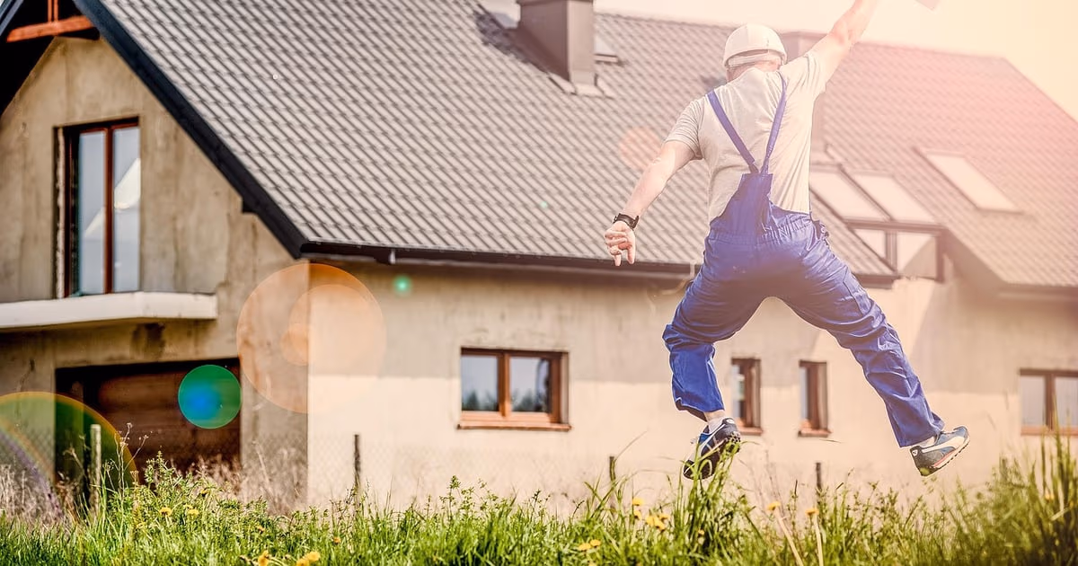 Roofing contractor on a ladder photographing storm damage on a shingle roof with a phone, representing CRM software for roofing companies in 2026