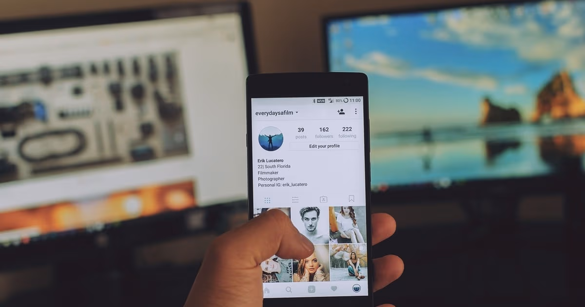 Small business owner holding a phone with Instagram open, representing turning Instagram activity into leads