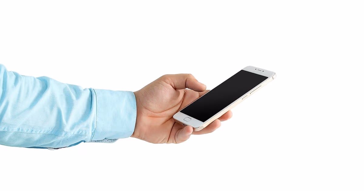Dueño de negocio usando WhatsApp en un smartphone para escribir a clientes