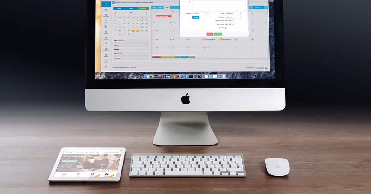 Desktop computer showing a calendar app beside a tablet, representing a planned WhatsApp follow-up sequence for leads