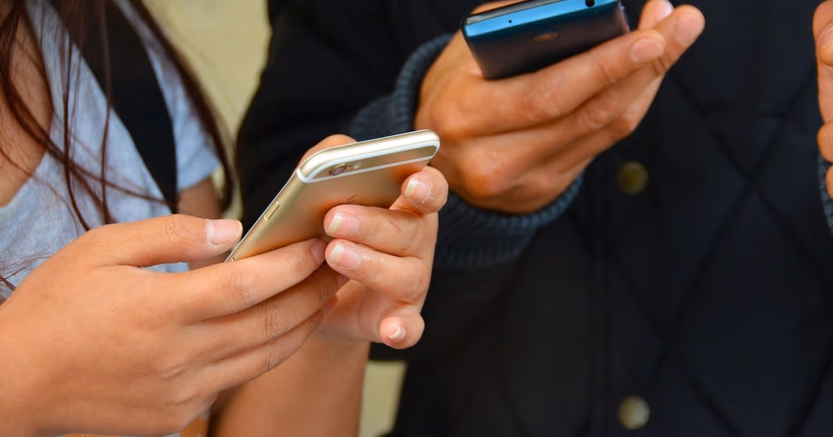 Small business owner reviewing qualified WhatsApp leads on a phone and laptop