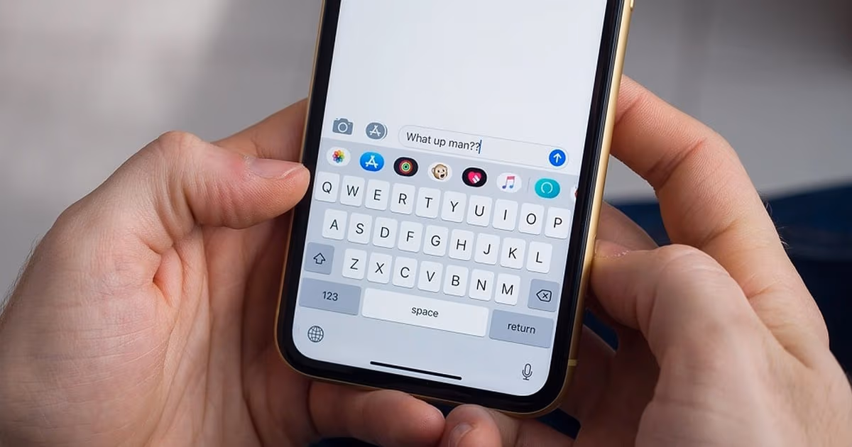 Small business owner drafting a WhatsApp message template on a laptop beside a phone