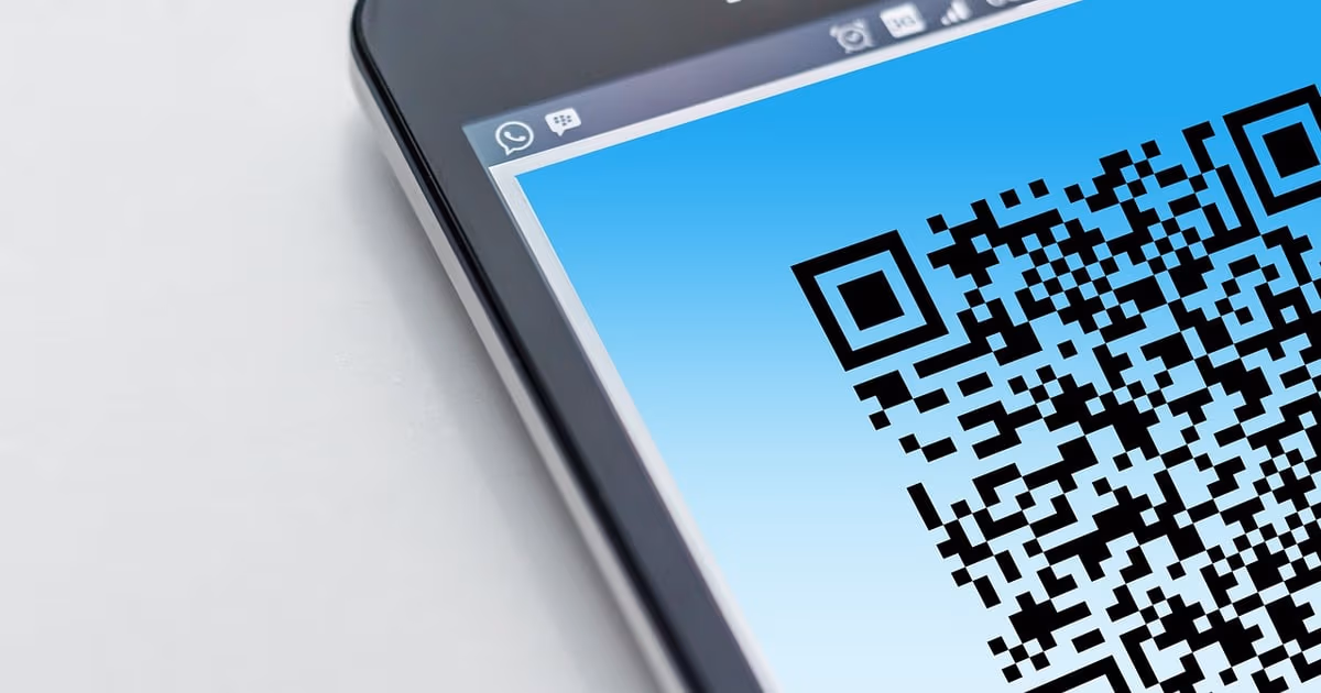 Printed WhatsApp QR code on a shop counter sign next to a phone opening a chat with a pre-filled message, representing a business click-to-chat link