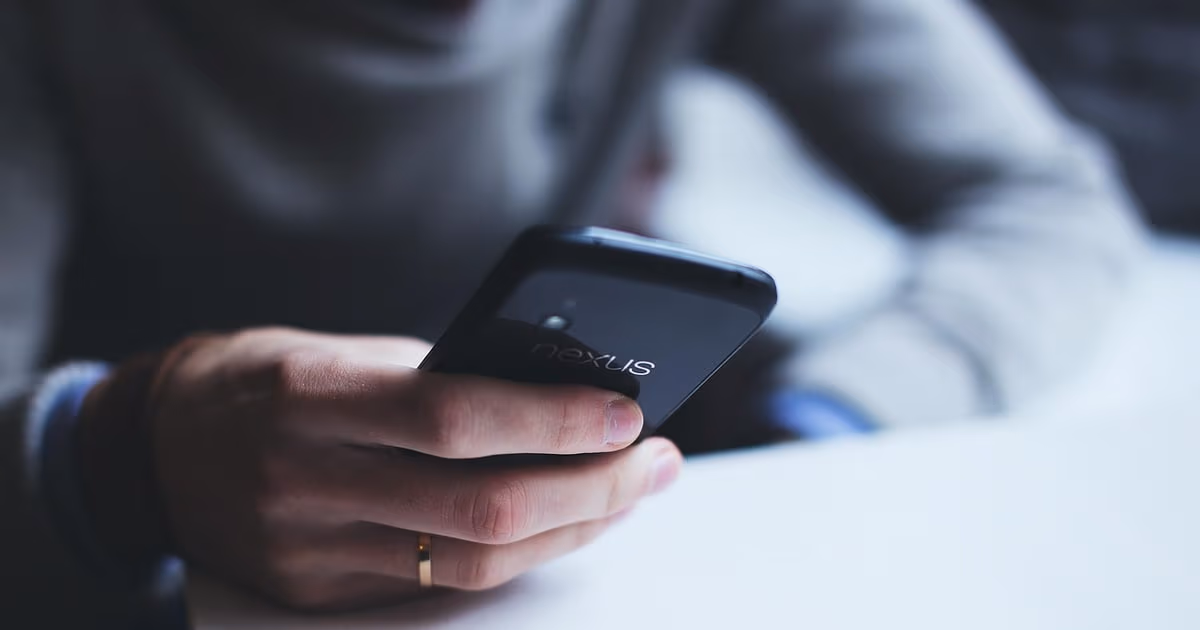 Two smartphones side by side, one showing a WhatsApp business chat and one showing an SMS text message, comparing the two channels